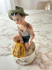 Statuetta Capodimonte “ ragazzo con cappello sedut