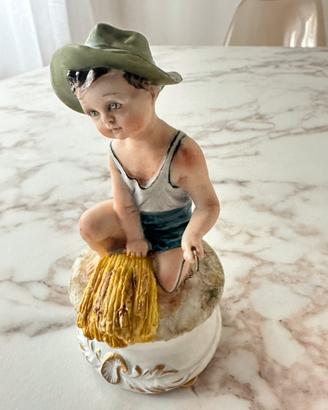 Statuetta Capodimonte “ ragazzo con cappello sedut