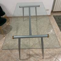 Tavolo con tavola in vetro e gambe in acciaio