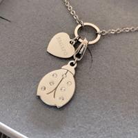 Collana con cuore pendente + ciondolo coccinella