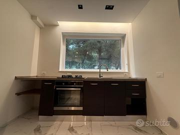 Cucina con lavandino, piano cottura e rubinetteria