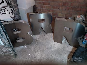 insegna a forma di lettera