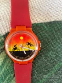 Orologio con moto, palma e tramonto