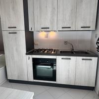 Cucina grigia compresa di elettrodomestici