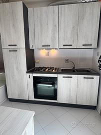 Cucina grigia compresa di elettrodomestici