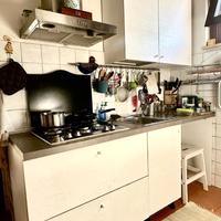 Cucina bianca con piano di lavoro grigio