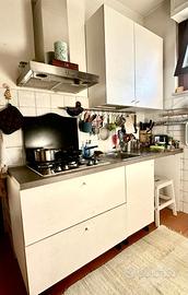 Cucina bianca con piano di lavoro grigio