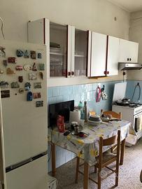 Cucina con  pensili +frigo  + tavolo e 2 sedie