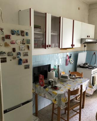 Cucina con  pensili +frigo  + tavolo e 2 sedie