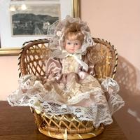 Bambola in porcellana con seduta vimini, vintage