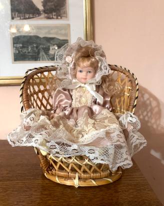 Bambola in porcellana con seduta vimini, vintage