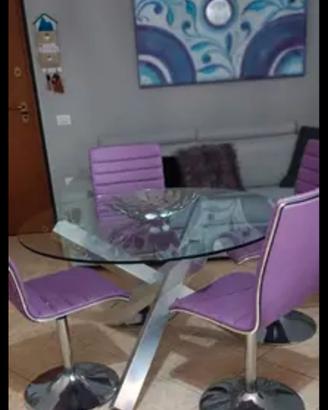 Tavolo design rotondo in vetro e metallo.