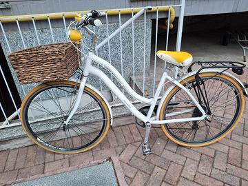 Bicicletta da città bianca con cestino in vimini