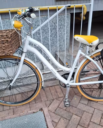 Bicicletta da città bianca con cestino in vimini
