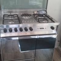 Cucina gas e forno tavolo sedie armadi scarpiera.