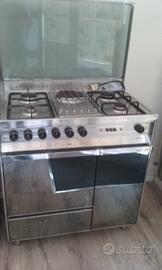 Cucina gas e forno tavolo sedie armadi scarpiera.