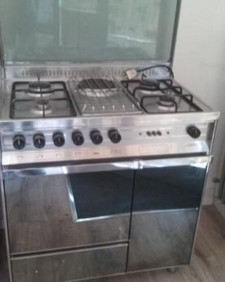 Cucina gas e forno tavolo sedie armadi scarpiera.