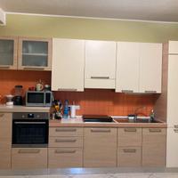 Cucina completa con tavolo, sedie e divano