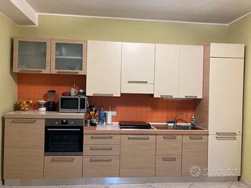 Cucina completa con tavolo, sedie e divano