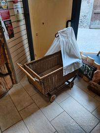 Carrozzina in vimini con ruote in legno