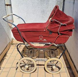 Carrozzina vintage d'epoca in velluto rosso