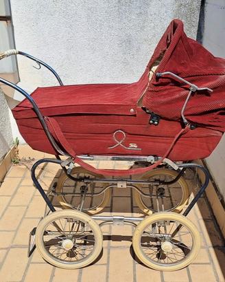 Carrozzina vintage d'epoca in velluto rosso