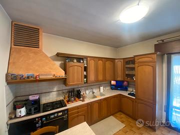 Cucina in legno compresa di cappa .