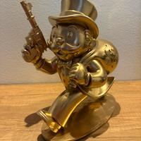 Statuetta di Mr. Monopoli con in mano unapistola