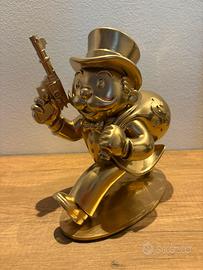 Statuetta di Mr. Monopoli con in mano unapistola
