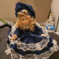 Bambola in porcellana su portagioie blu 