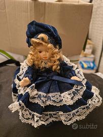 Bambola in porcellana su portagioie blu 