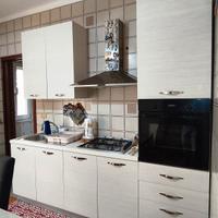 cucina con elettrodomestici, tavolo e sedie