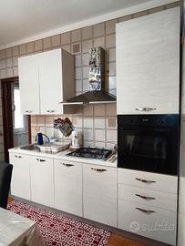 cucina con elettrodomestici, tavolo e sedie