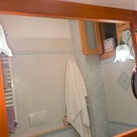 Specchio con cornice in legno e due lampade .