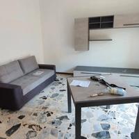 Parete attrezzata con tavolo e divano color cement