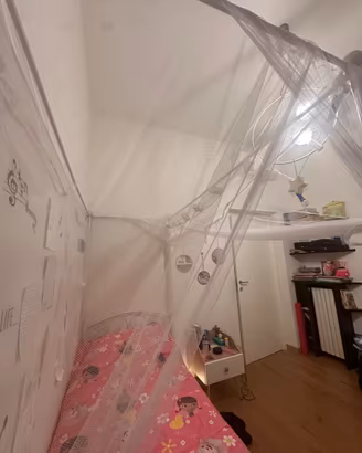 Letto a baldacchino con tenda di velo bianco