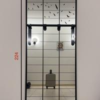 Specchio con cornice in metallo e decoro a griglia