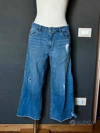 Jeans flare blu con strappi e fondo sfrangiato