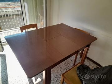 Tavolo in legno scuro allungabile con 4 sedie. 
