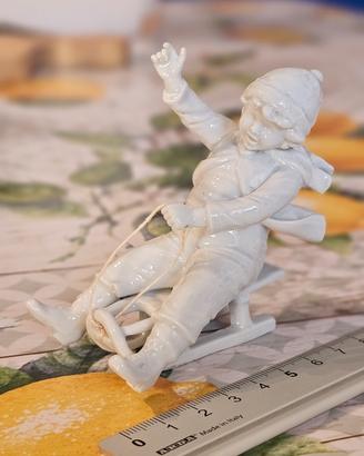 Statuina Capodimonte di bambino sullo slittino