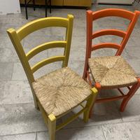 Due sedie colorate in legno con seduta in paglia