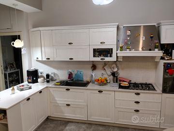 cucina con elettrodomestici  e tavolo