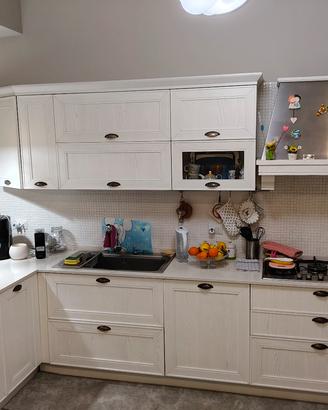 cucina con elettrodomestici  e tavolo