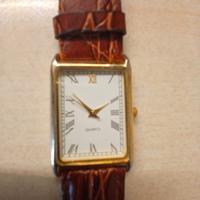 orologio quadrante rettangolare color oro.