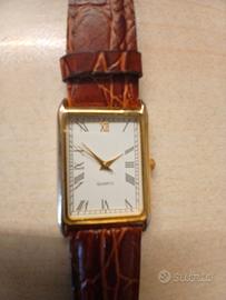 orologio quadrante rettangolare color oro.