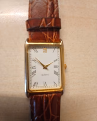 orologio quadrante rettangolare color oro.