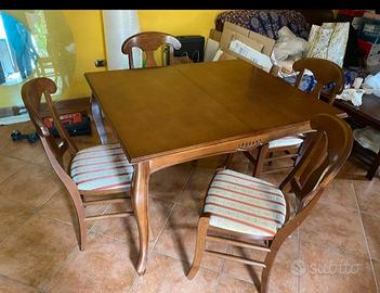 Cucina con frigo, lavatrice, tavolo, sei sedie.