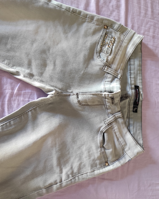 Jeans sbiaditi con borchie sulle tasche