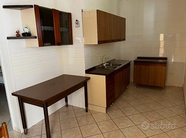 cucina con tavolo e mobiletti vari