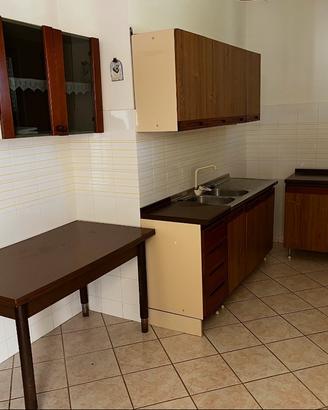 cucina con tavolo e mobiletti vari